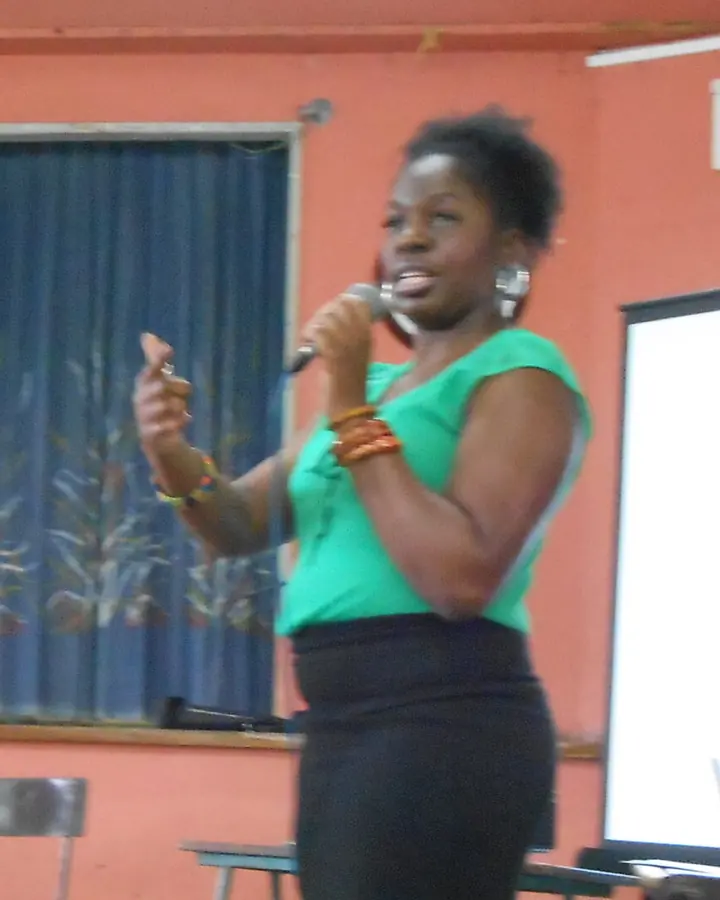 Judy Harrison presenting with a microphone at a creative therapy workshop in the Caribbean